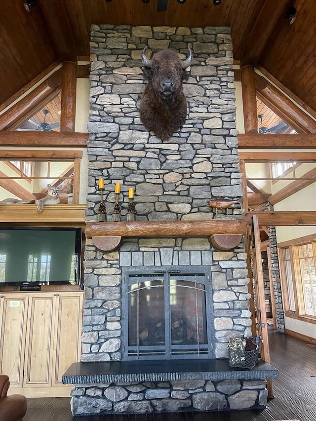 details featuring hardwood / wood-style floors, wood ceiling, a stone fireplace, and beam ceiling