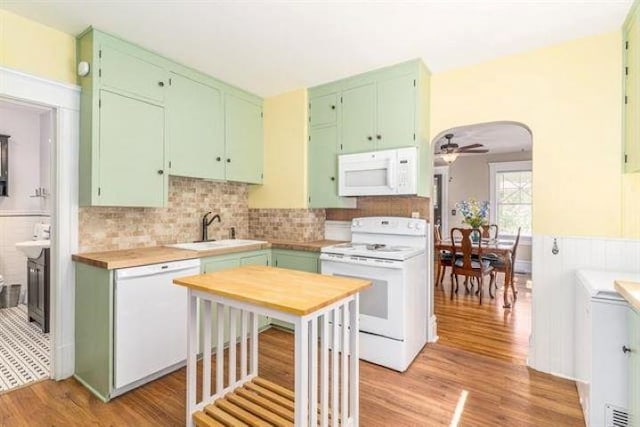 kitchen featuring white appliances, ceiling fan, light wood-type flooring, and sink