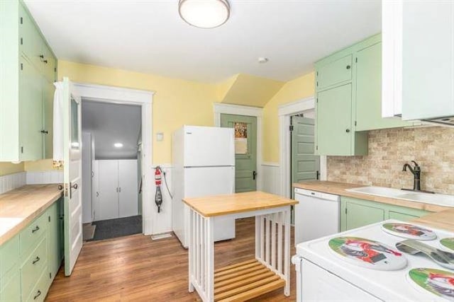 kitchen featuring white appliances, green cabinets, decorative backsplash, and sink