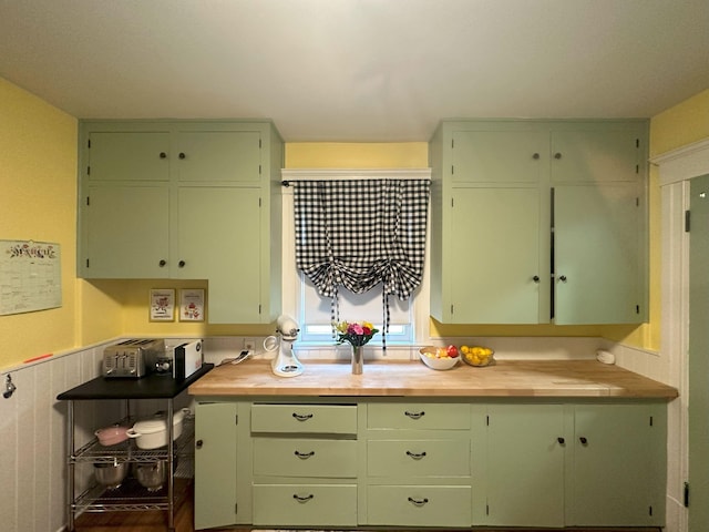 kitchen featuring butcher block countertops and green cabinets