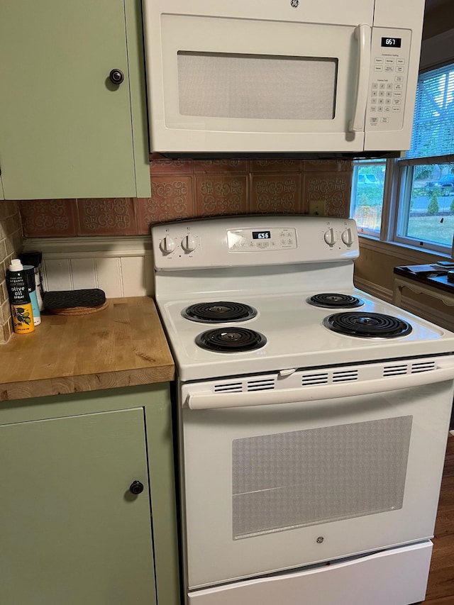 kitchen featuring green cabinetry, white appliances, and tasteful backsplash