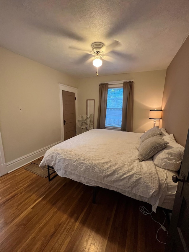 bedroom featuring a textured ceiling, ceiling fan, and wood-type flooring