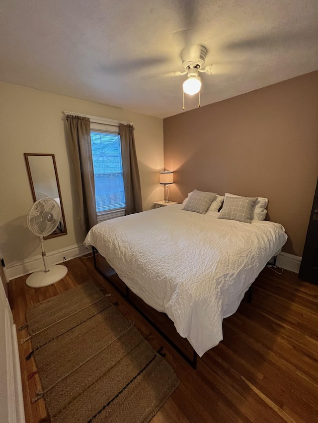 bedroom with ceiling fan and dark hardwood / wood-style flooring