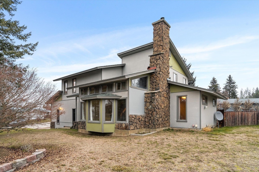 rear view of property featuring a lawn