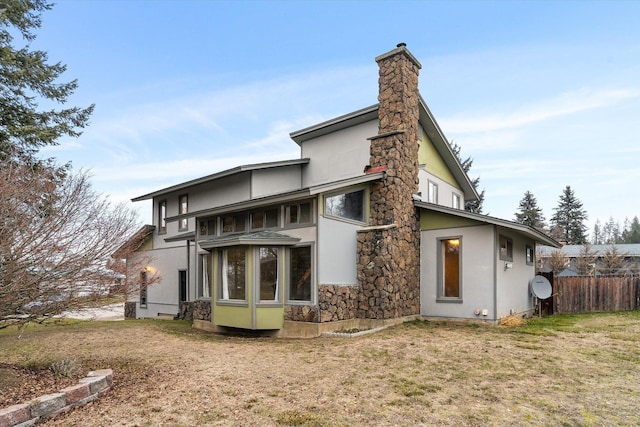 rear view of property featuring a lawn