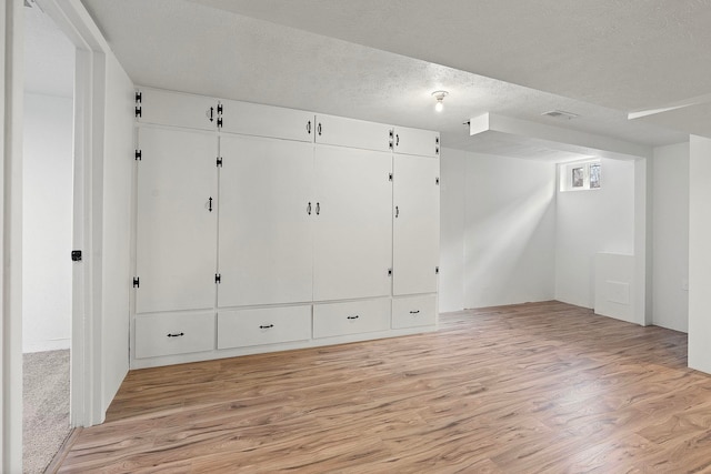 interior space featuring light hardwood / wood-style floors and a textured ceiling