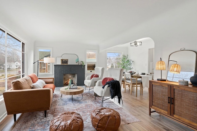 living room with light hardwood / wood-style floors, an inviting chandelier, and a fireplace