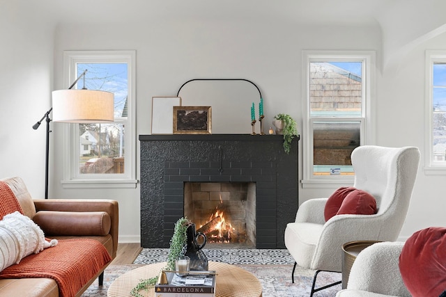 living room with a brick fireplace and light hardwood / wood-style floors