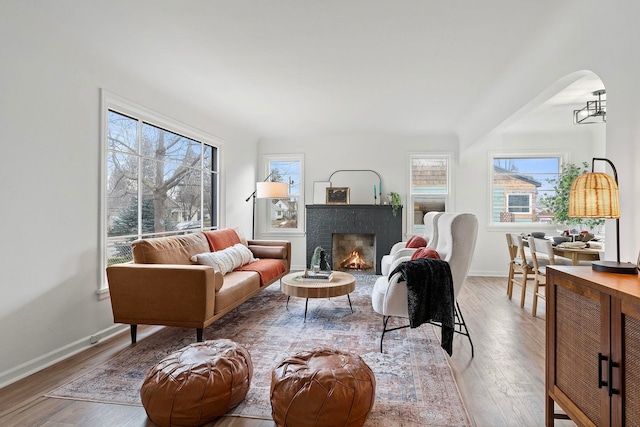 living room featuring a brick fireplace and light hardwood / wood-style flooring