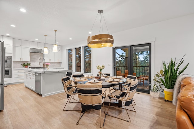 dining space featuring sink and light hardwood / wood-style flooring