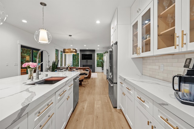 kitchen with sink, white cabinetry, pendant lighting, and appliances with stainless steel finishes