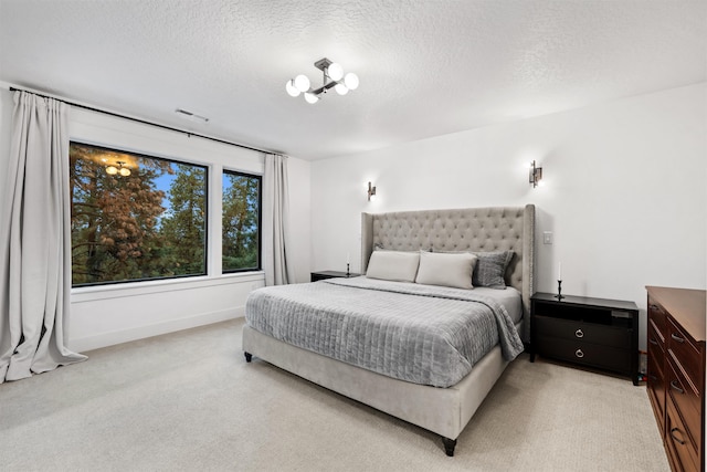 bedroom with a textured ceiling and light colored carpet