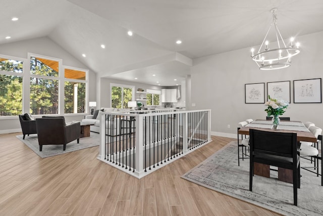 dining room featuring lofted ceiling, a chandelier, and light hardwood / wood-style floors