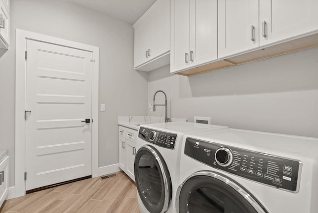 laundry area featuring sink, washer and dryer, and cabinets