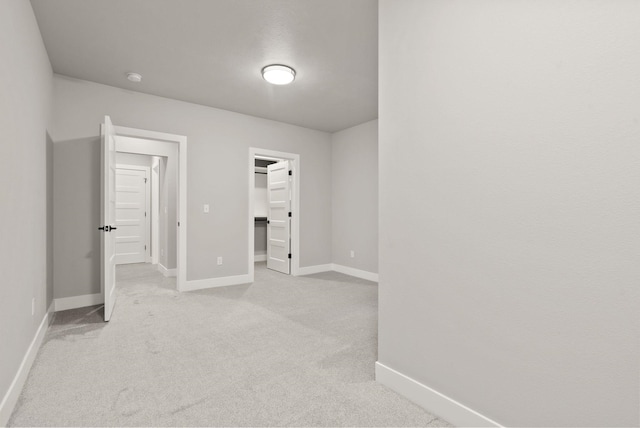 interior space with a spacious closet, a closet, and light colored carpet