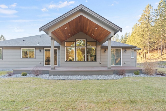 rear view of property featuring a lawn