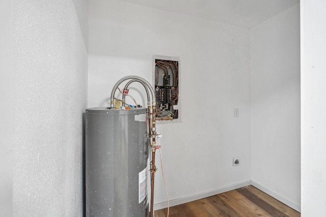 utility room featuring electric panel and water heater