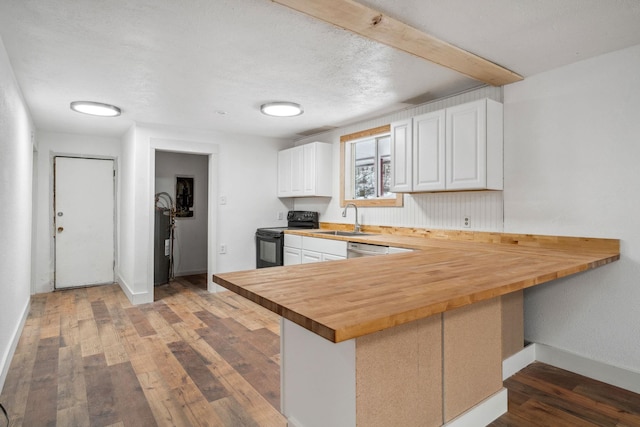 kitchen featuring kitchen peninsula, black electric range oven, wooden counters, white cabinetry, and sink