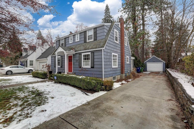 view of front of house with a garage and an outbuilding