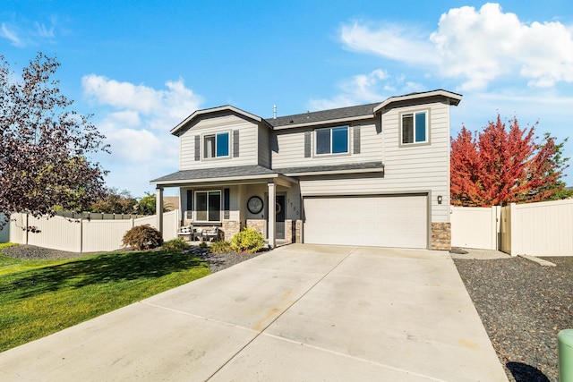 view of front of home featuring a garage, a front lawn, and covered porch