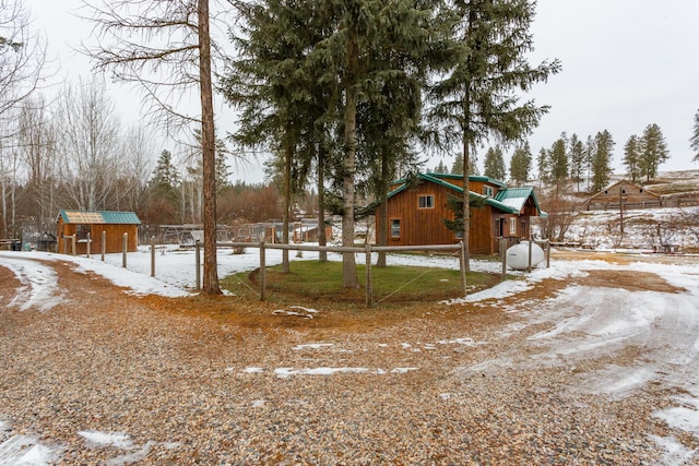 snowy yard featuring a storage shed