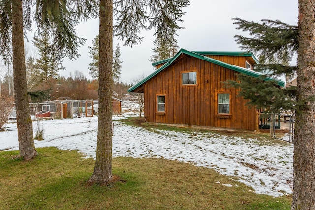 view of snowy exterior featuring a lawn