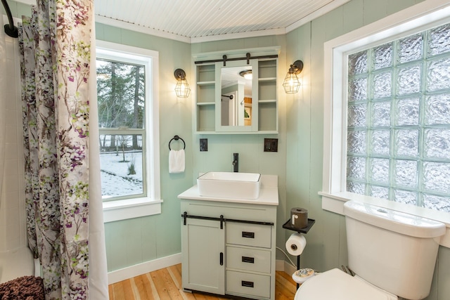 bathroom featuring wood-type flooring, vanity, toilet, ornamental molding, and a shower with shower curtain