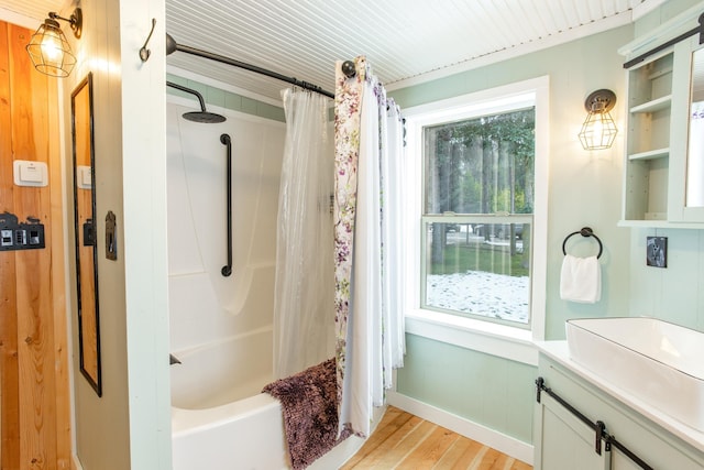 bathroom with a healthy amount of sunlight, hardwood / wood-style flooring, vanity, and shower / tub combo with curtain