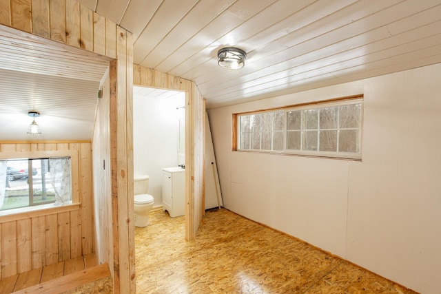 interior space featuring wooden ceiling and wooden walls