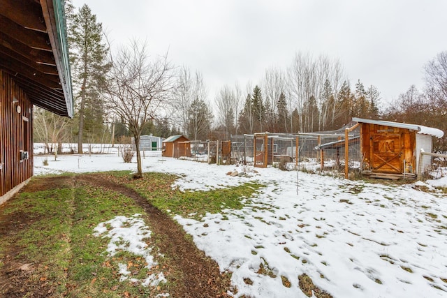 yard covered in snow featuring a shed