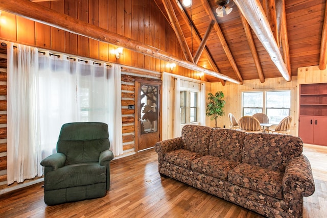 living room featuring hardwood / wood-style floors, vaulted ceiling with beams, wood walls, ceiling fan, and wooden ceiling