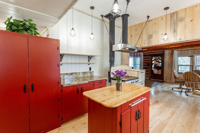 kitchen featuring pendant lighting, wood walls, wooden counters, and a kitchen island