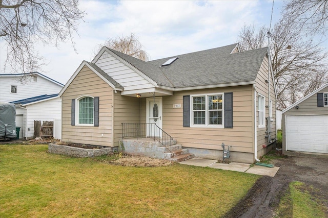 bungalow with a front yard, a garage, and an outdoor structure