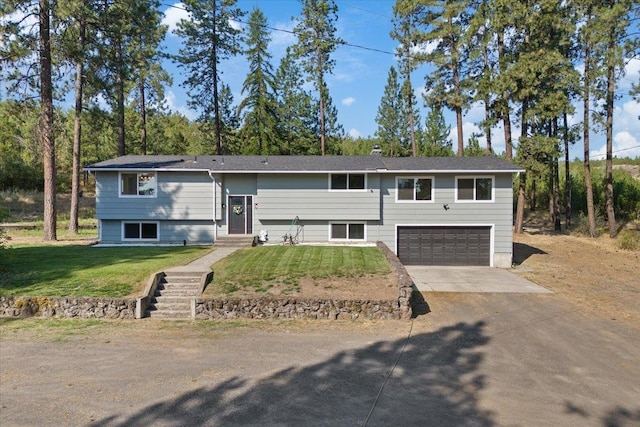 raised ranch featuring a front yard and a garage