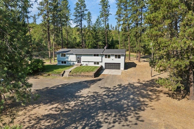 bi-level home with a garage and a front lawn