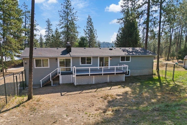 back of house with a wooden deck and a lawn