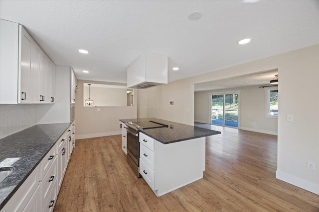 kitchen featuring pendant lighting, white cabinets, dark stone counters, electric range, and light hardwood / wood-style flooring