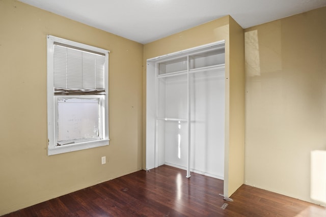 unfurnished bedroom featuring dark wood-type flooring and a closet