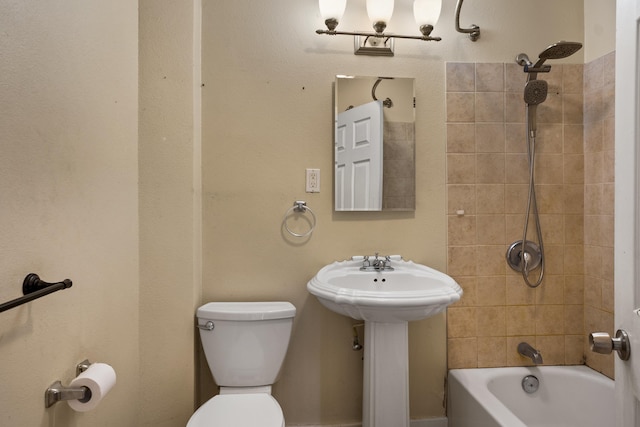 bathroom featuring toilet and tiled shower / bath combo