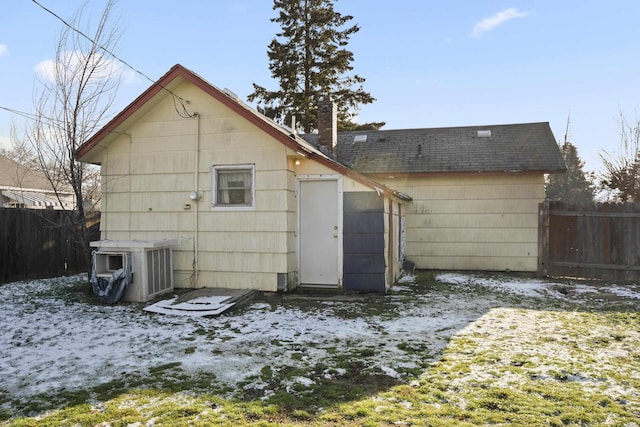 snow covered back of property featuring central AC