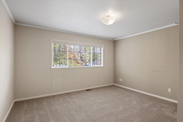 empty room featuring crown molding and light colored carpet