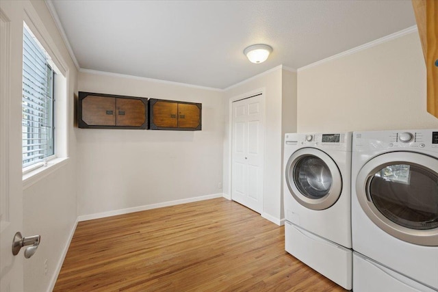 washroom with a textured ceiling, light hardwood / wood-style flooring, crown molding, and washing machine and dryer