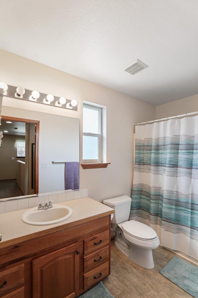 full bathroom featuring toilet, shower / bathtub combination with curtain, and vanity