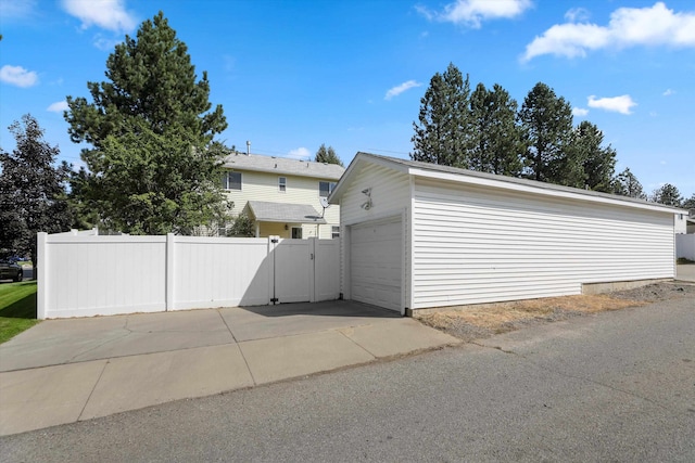 view of property exterior with a garage and an outbuilding