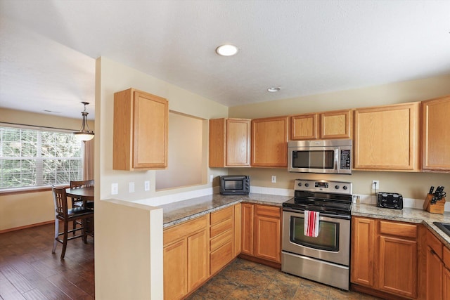 kitchen with decorative light fixtures, light stone counters, and stainless steel appliances