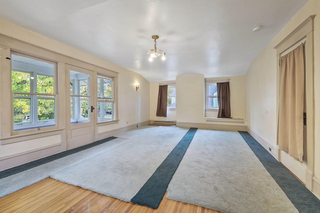 interior space with wood-type flooring, an inviting chandelier, and a baseboard radiator