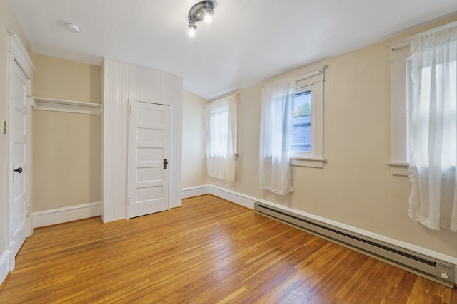 unfurnished bedroom featuring a closet, light hardwood / wood-style floors, and a baseboard radiator