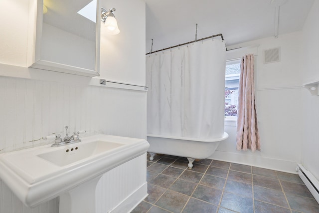 bathroom with baseboard heating, a bathtub, and sink