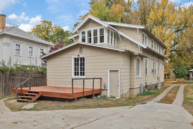 rear view of house featuring a wooden deck