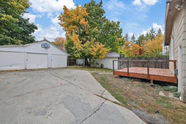 view of yard featuring an outbuilding, a wooden deck, and a garage